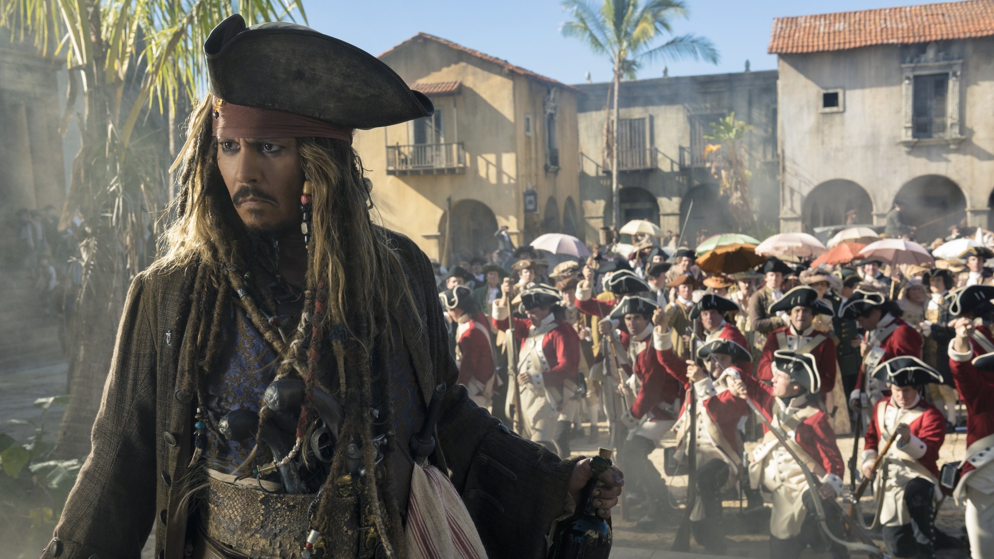 Johnny Depp como Jack Sparrow camina por una plaza colonial mientras una columna de soldados con casacas rojas avanza detrás de él
