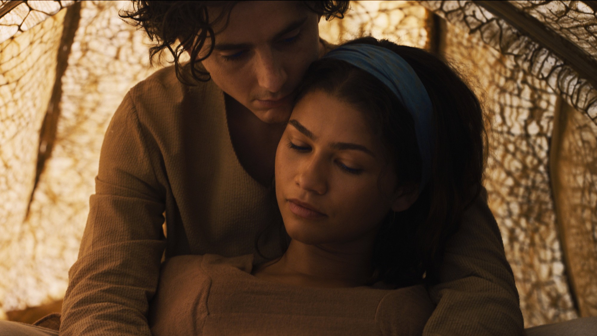 Timothée Chalamet abraza a Zendaya dentro de una tienda fremen iluminada por luz cálida en 'Duna: Parte Tres'