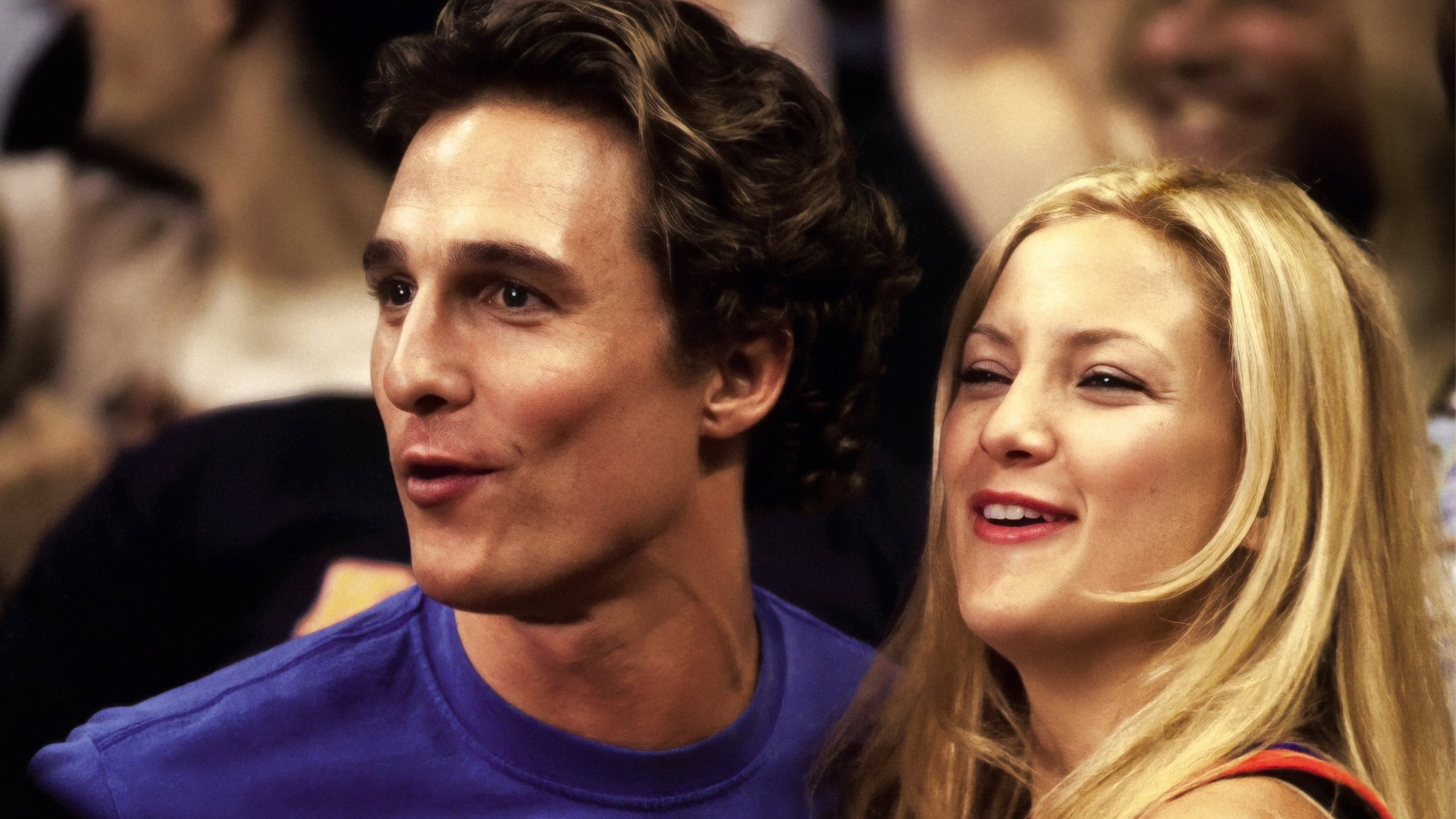 Matthew McConaughey y Kate Hudson sonríen sentados entre el público de un partido de básquetbol en Madison Square Garden