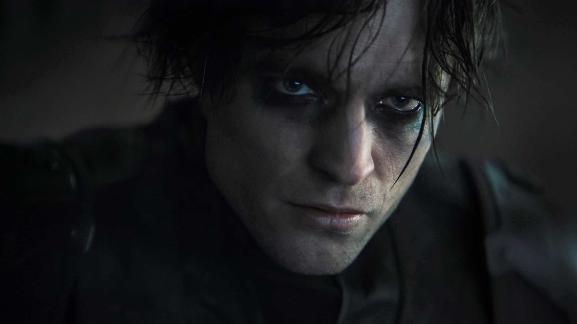 Robert Pattinson como Bruce Wayne, sin la máscara, con el rostro marcado por el maquillaje oscuro alrededor de los ojos