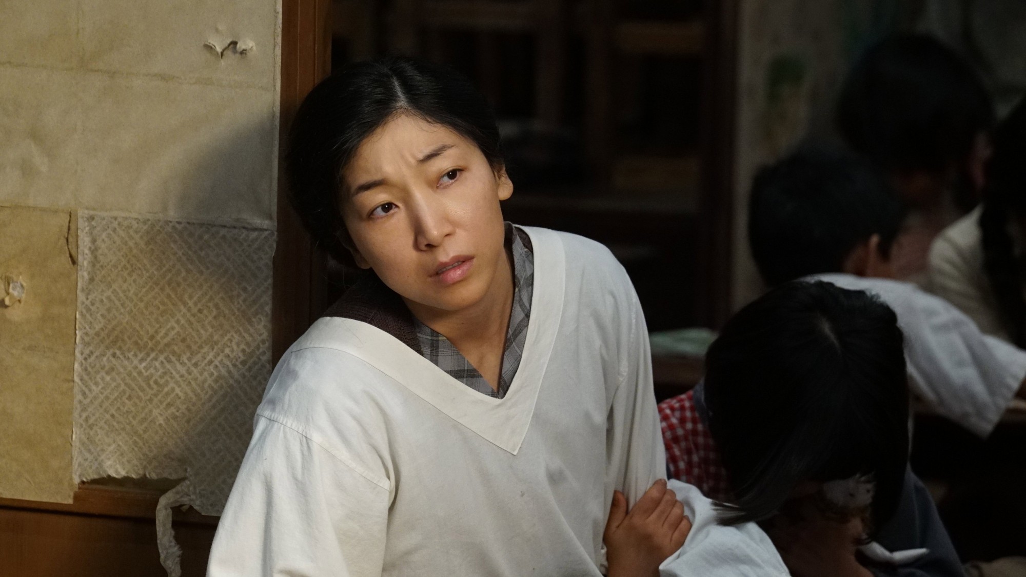 Minami Hamabe en una escena de interior de la posguerra japonesa, con gesto de preocupación
