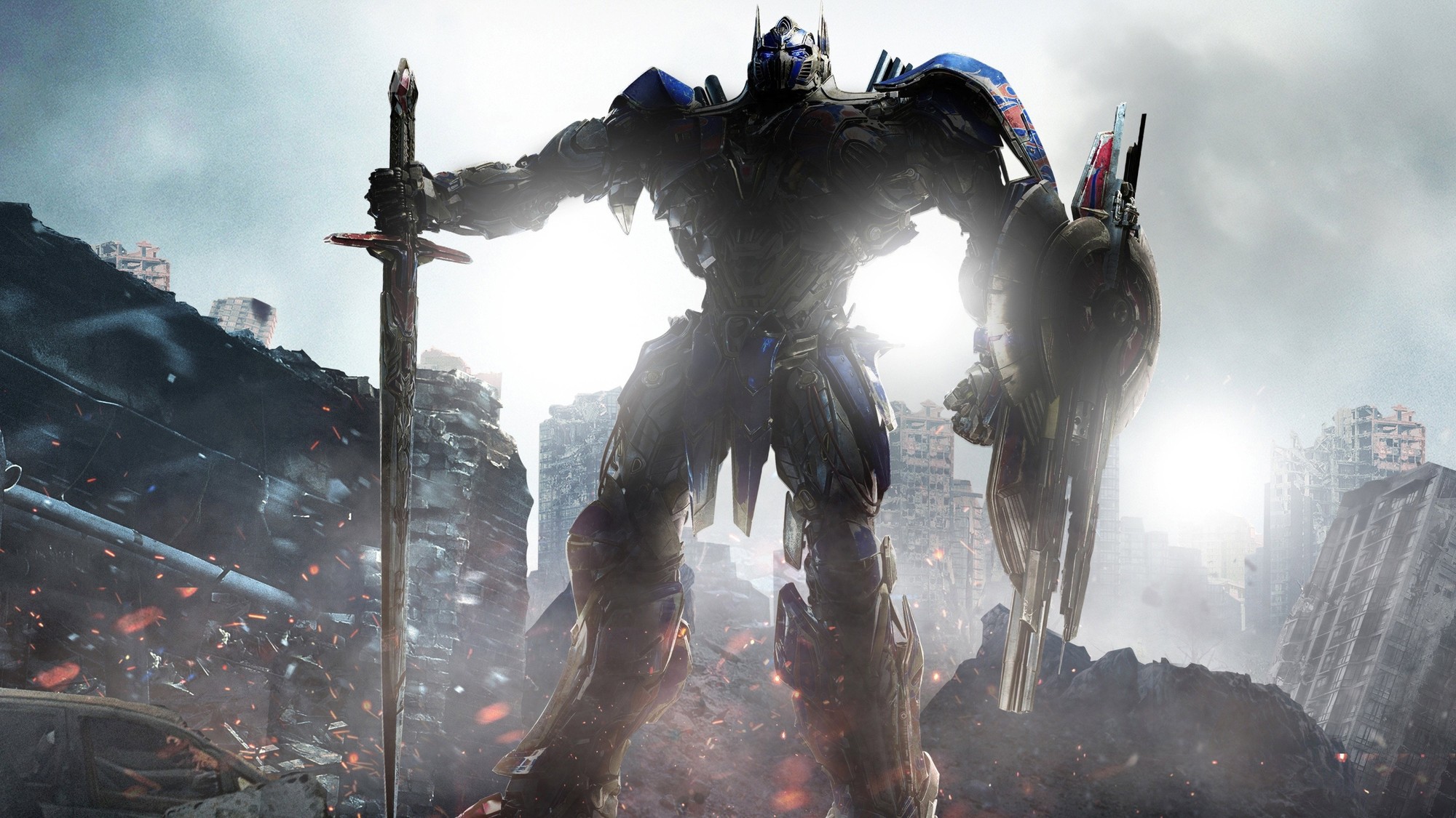 Optimus Prime de pie entre ruinas humeantes, con una espada en la mano, en Transformers: The Last Knight