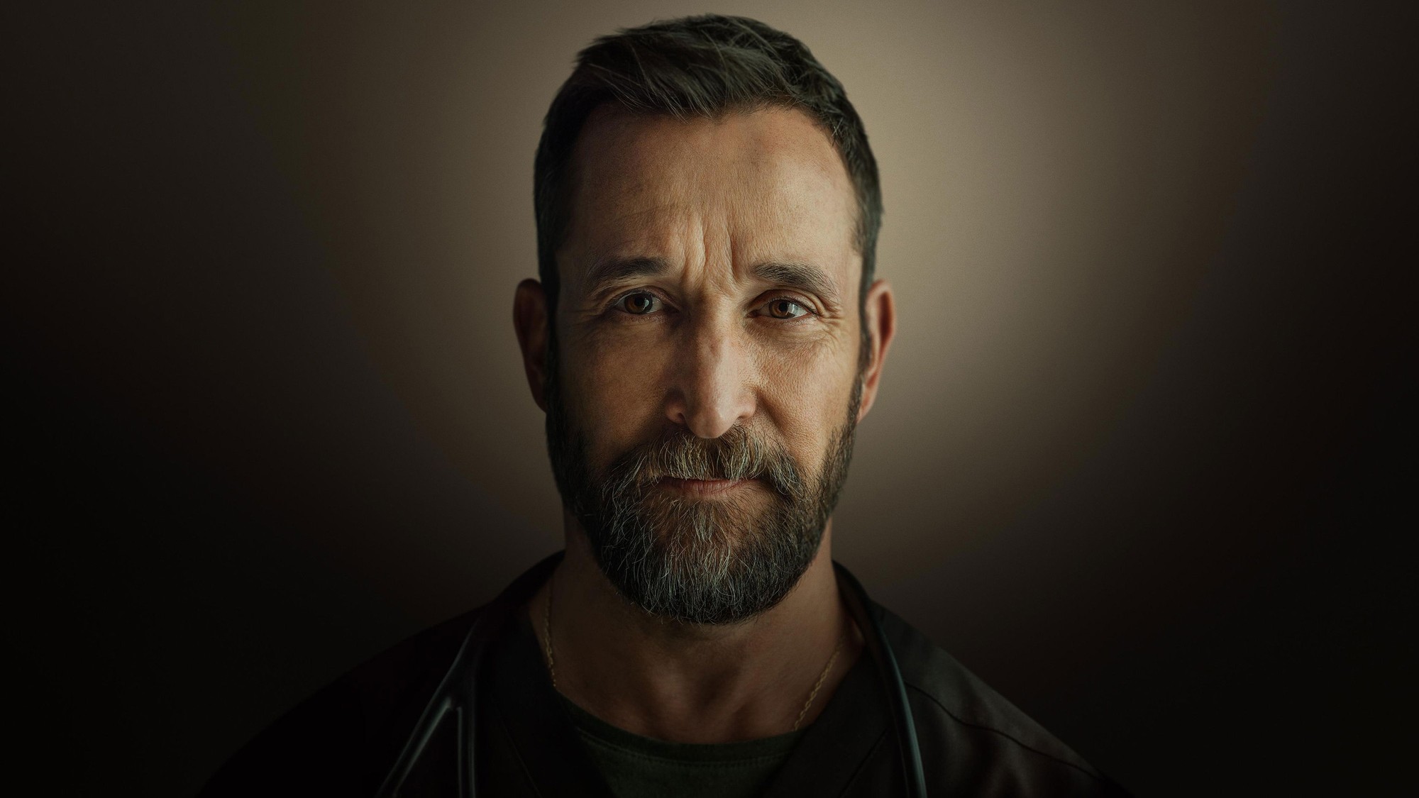 Retrato de Noah Wyle con estetoscopio sobre fondo oscuro