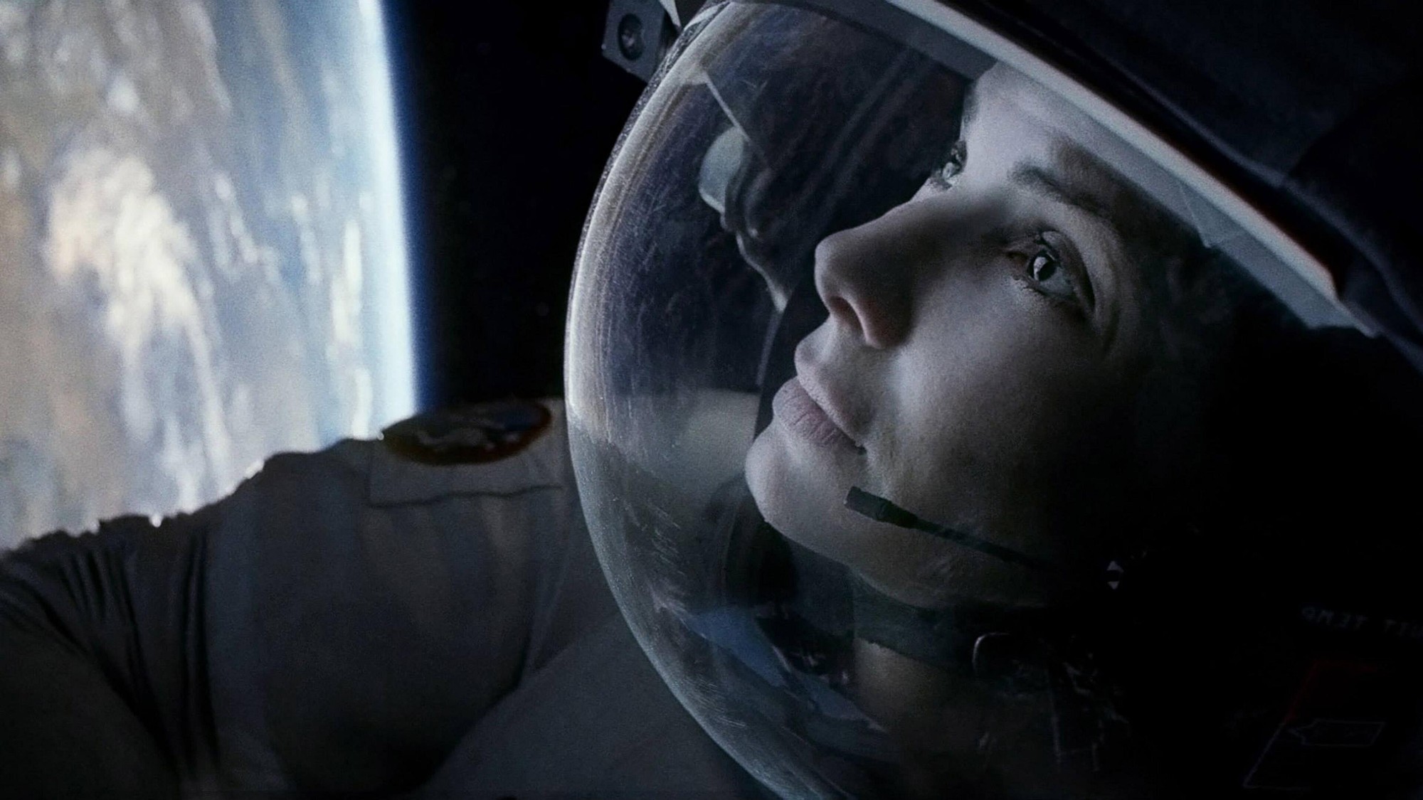 Sandra Bullock con casco de astronauta mira hacia la Tierra en una escena de Gravity
