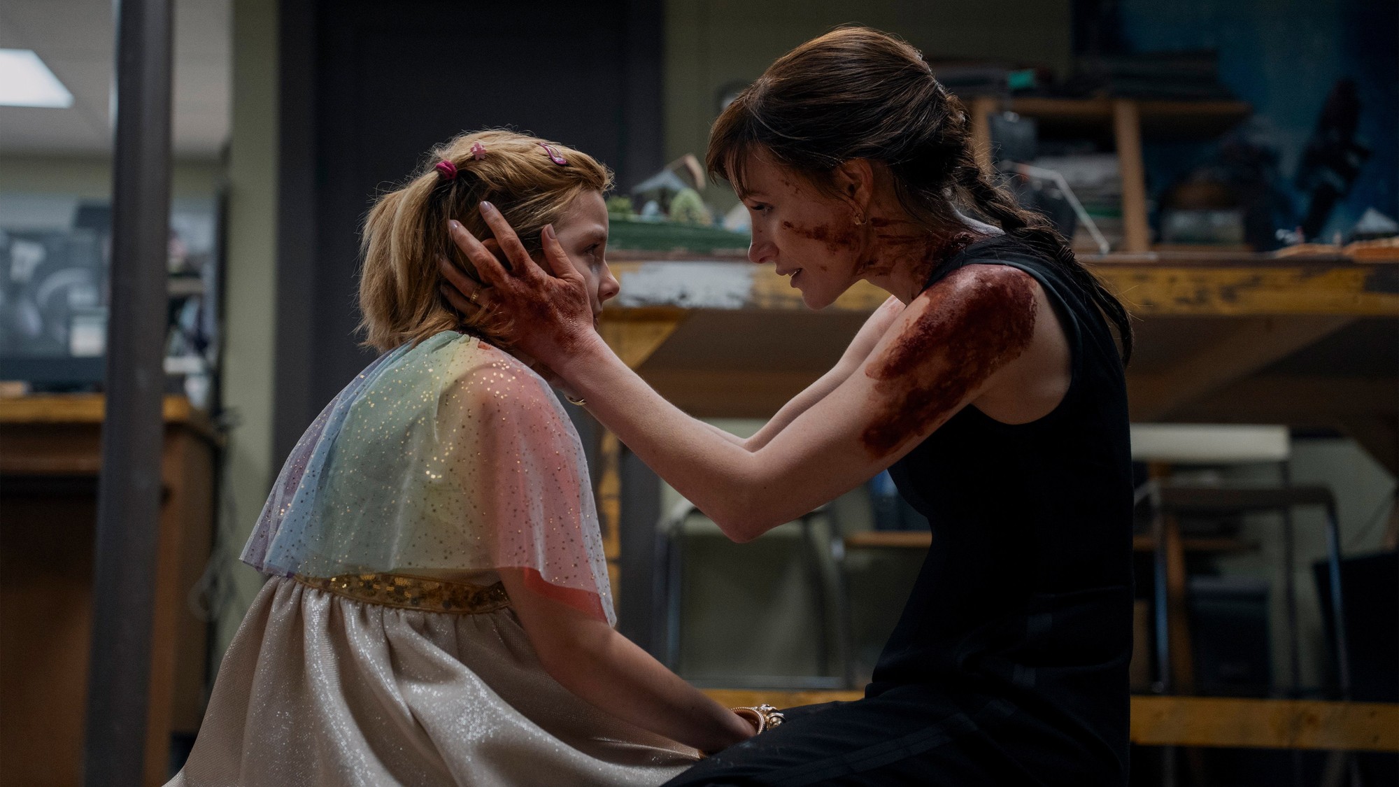 Jessica Chastain, con manchas de sangre, sostiene el rostro de una niña disfrazada en Other Mommy