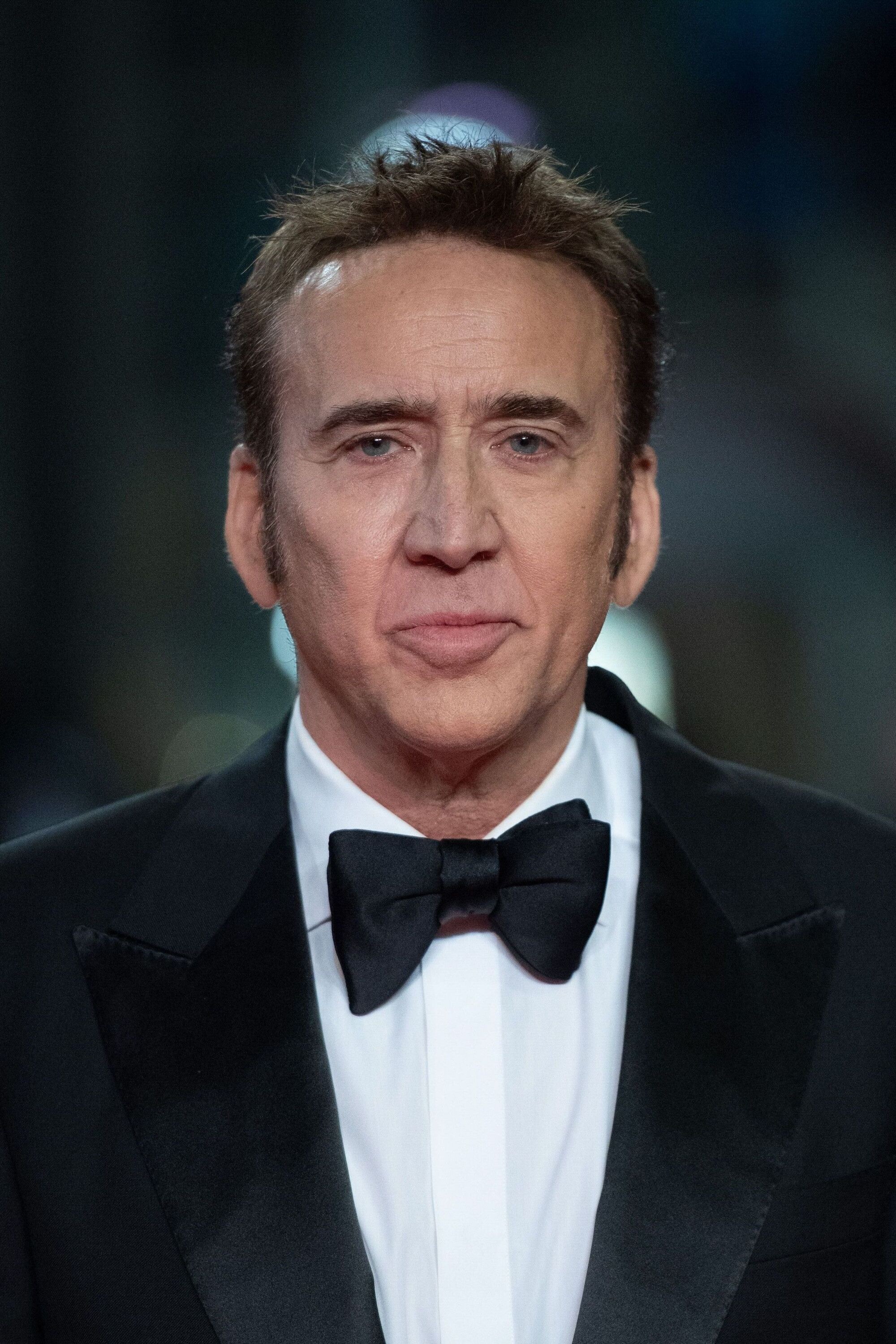 Nicolas Cage con esmoquin y moño negro posa en una alfombra roja