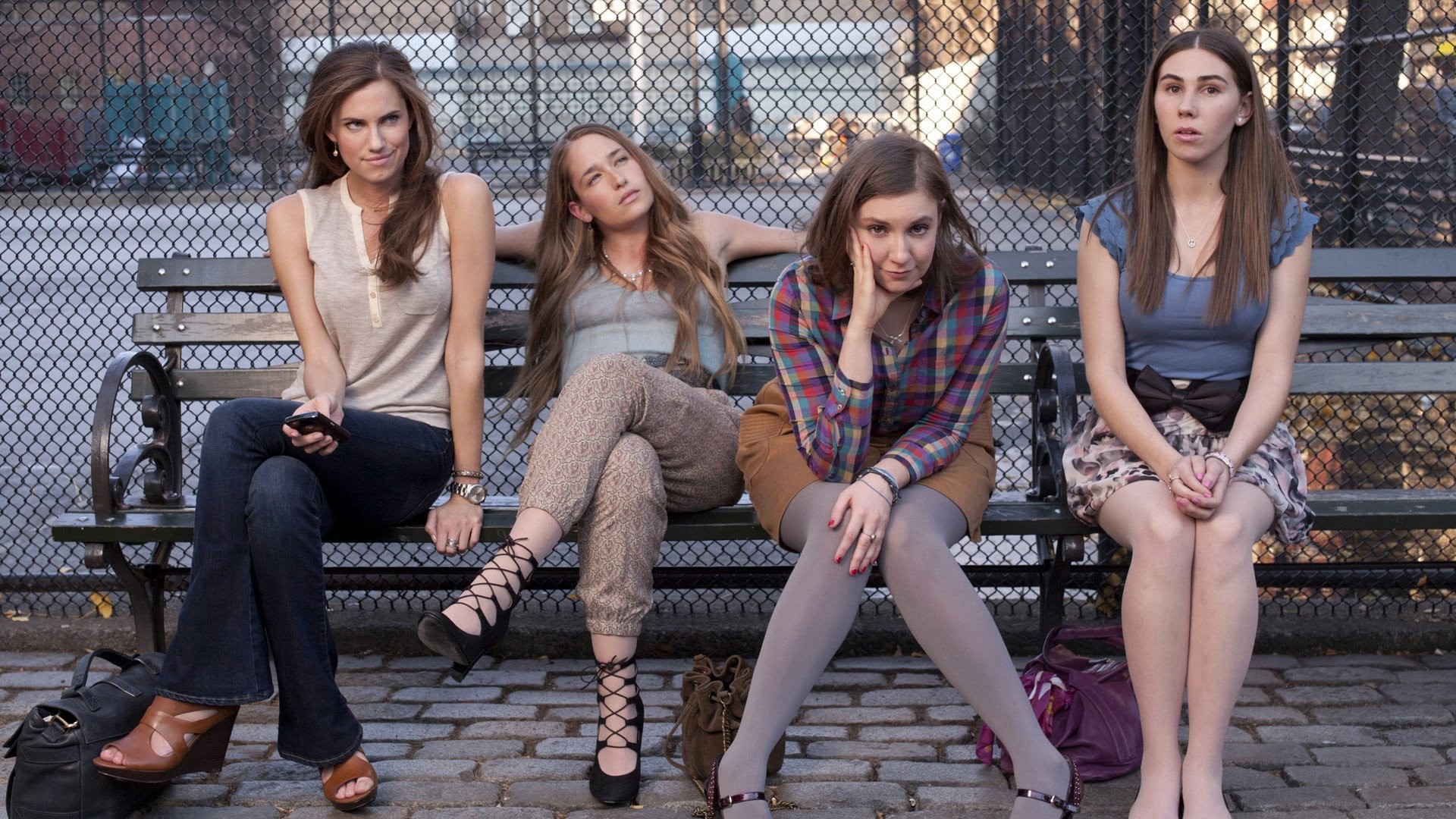 Allison Williams, Jemima Kirke, Lena Dunham y Zosia Mamet sentadas en una banca de Nueva York en la primera temporada de Girls