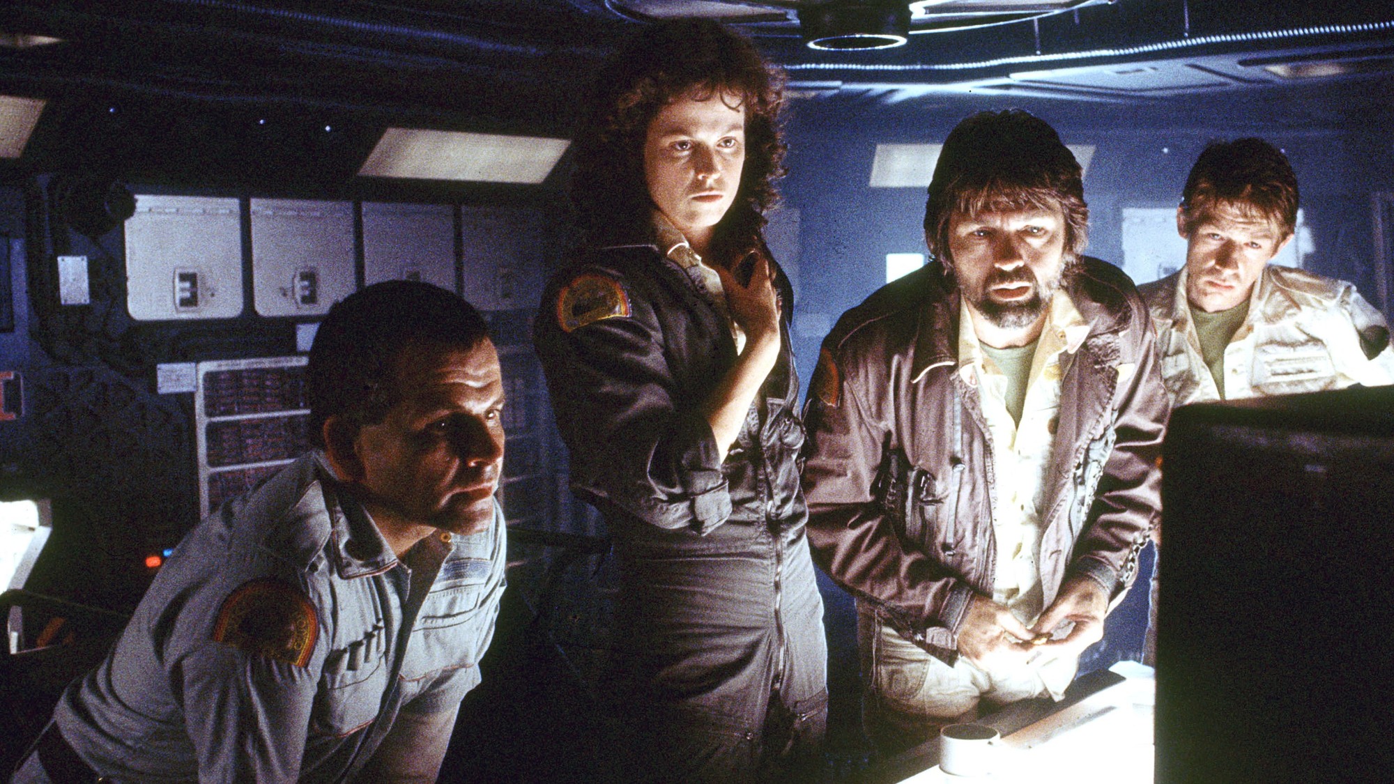 El capitán Dallas, interpretado por Tom Skerritt, observa una consola junto a Ripley y otros tripulantes del Nostromo en Alien