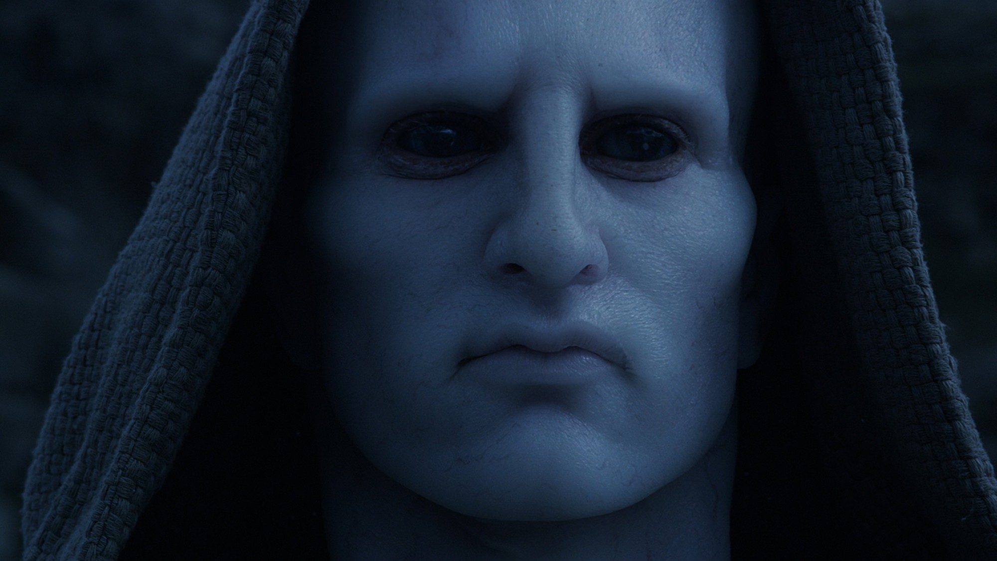 Primer plano de un Ingeniero, de piel pálida y ojos oscuros, cubierto con una capucha en Prometheus