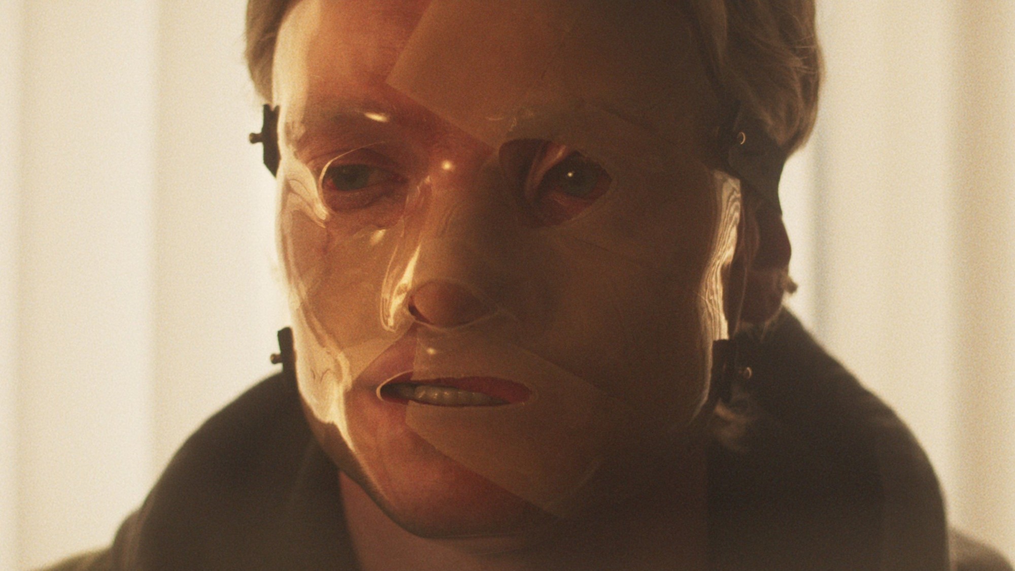 Matt Hagen, interpretado por Tom Rhys Harries, con una máscara transparente sujeta al rostro deformado en Clayface