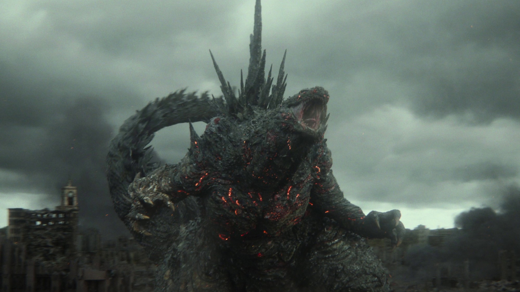 Godzilla ruge con el cuerpo cubierto de grietas incandescentes bajo un cielo gris en Godzilla Minus Zero