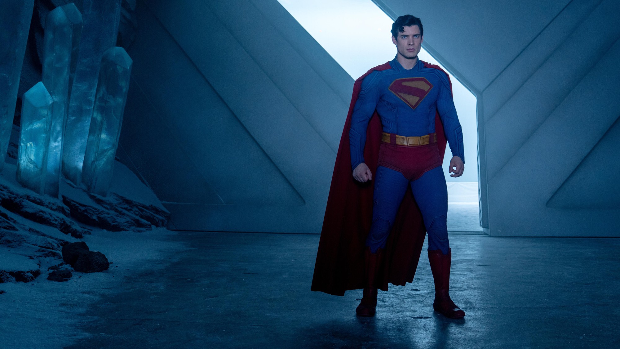 David Corenswet como Superman de pie en la Fortaleza de la Soledad, junto a columnas de cristal