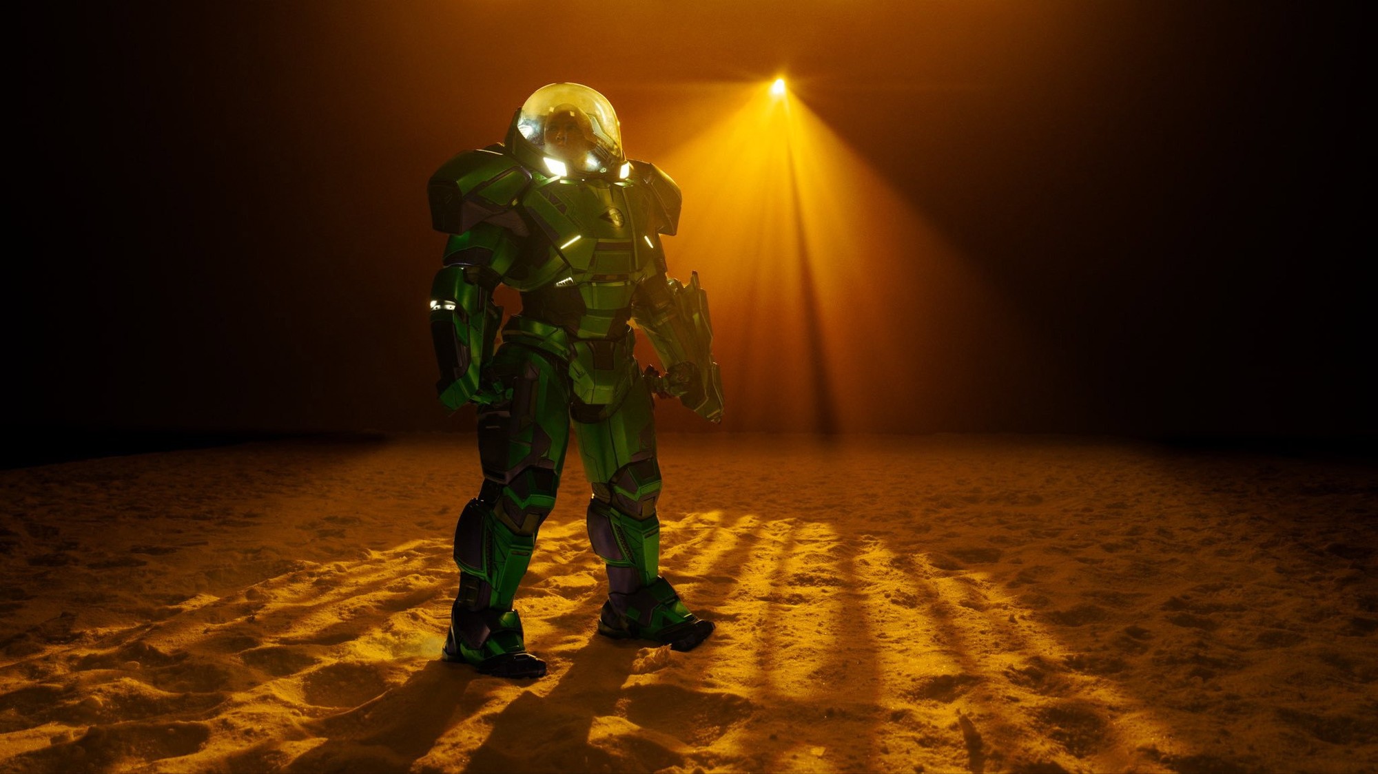 Figura con armadura de combate verde y casco transparente bajo un haz de luz en una imagen de Man of Tomorrow